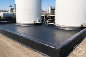 Black geomembrane liner surrounding industrial water pond